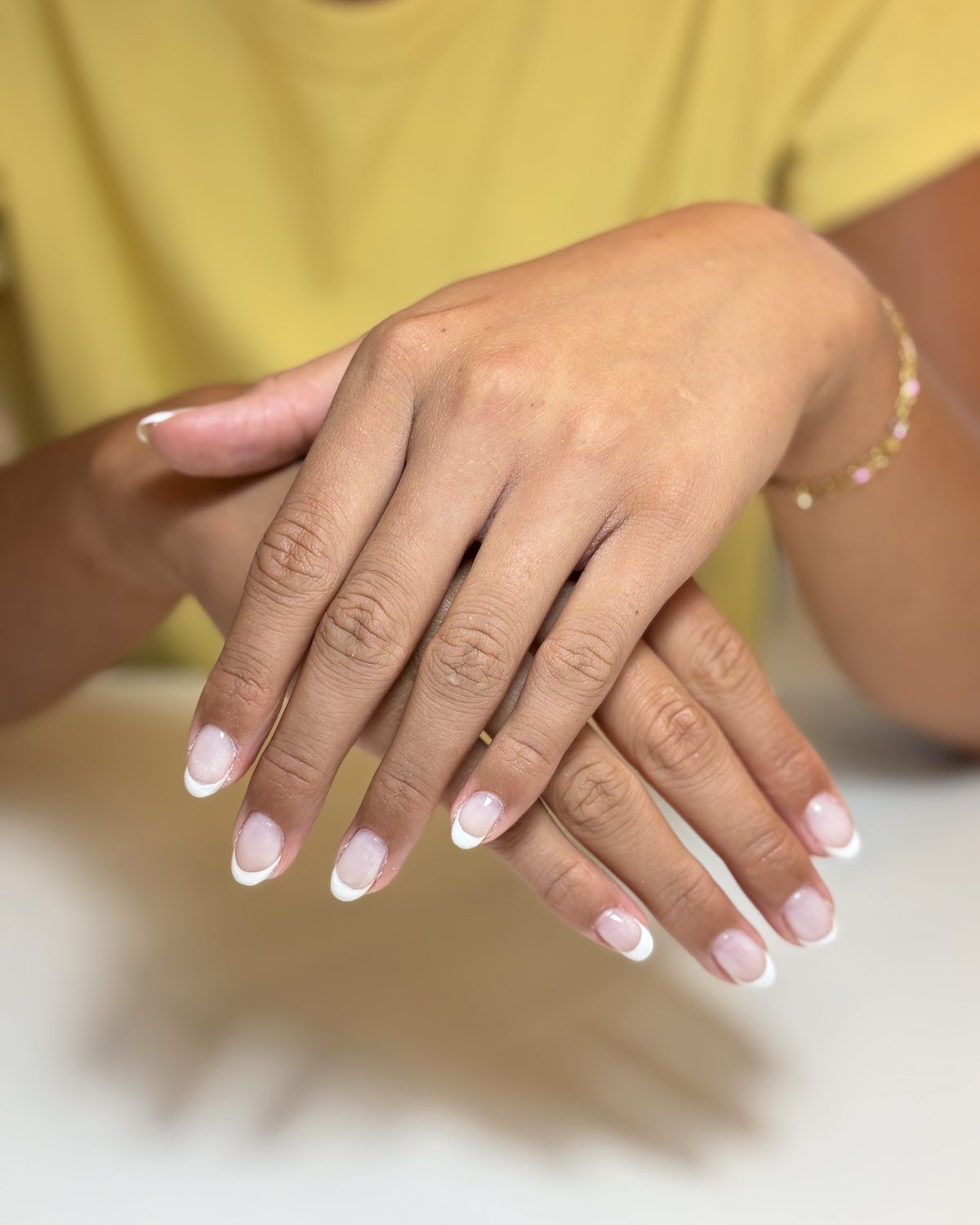 A crisp white French tip on short, squared natural nails.